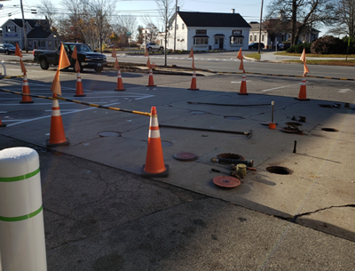 connected orange safety cones used to barricade the work area of the underground storage tank riser pad 